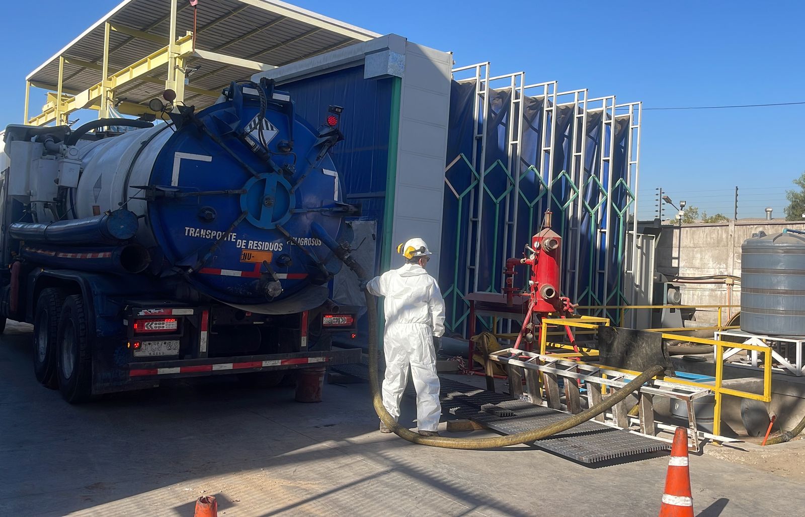 Operador con protección trabajando junto a un camión de vacío